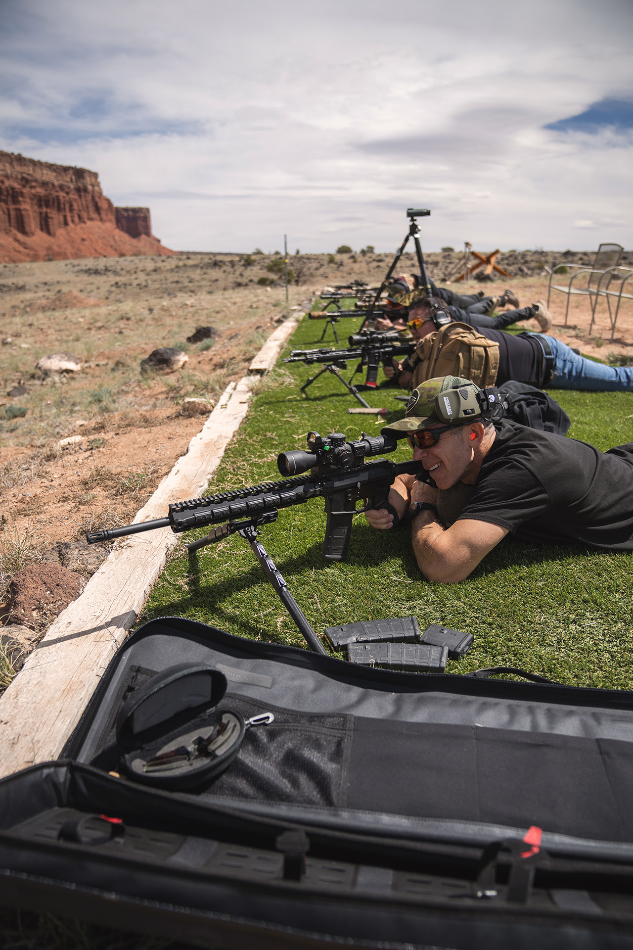 Shooter aiming an AR-15 rifle during Buck Doyle scoped carbine training on a long-range outdoor course.